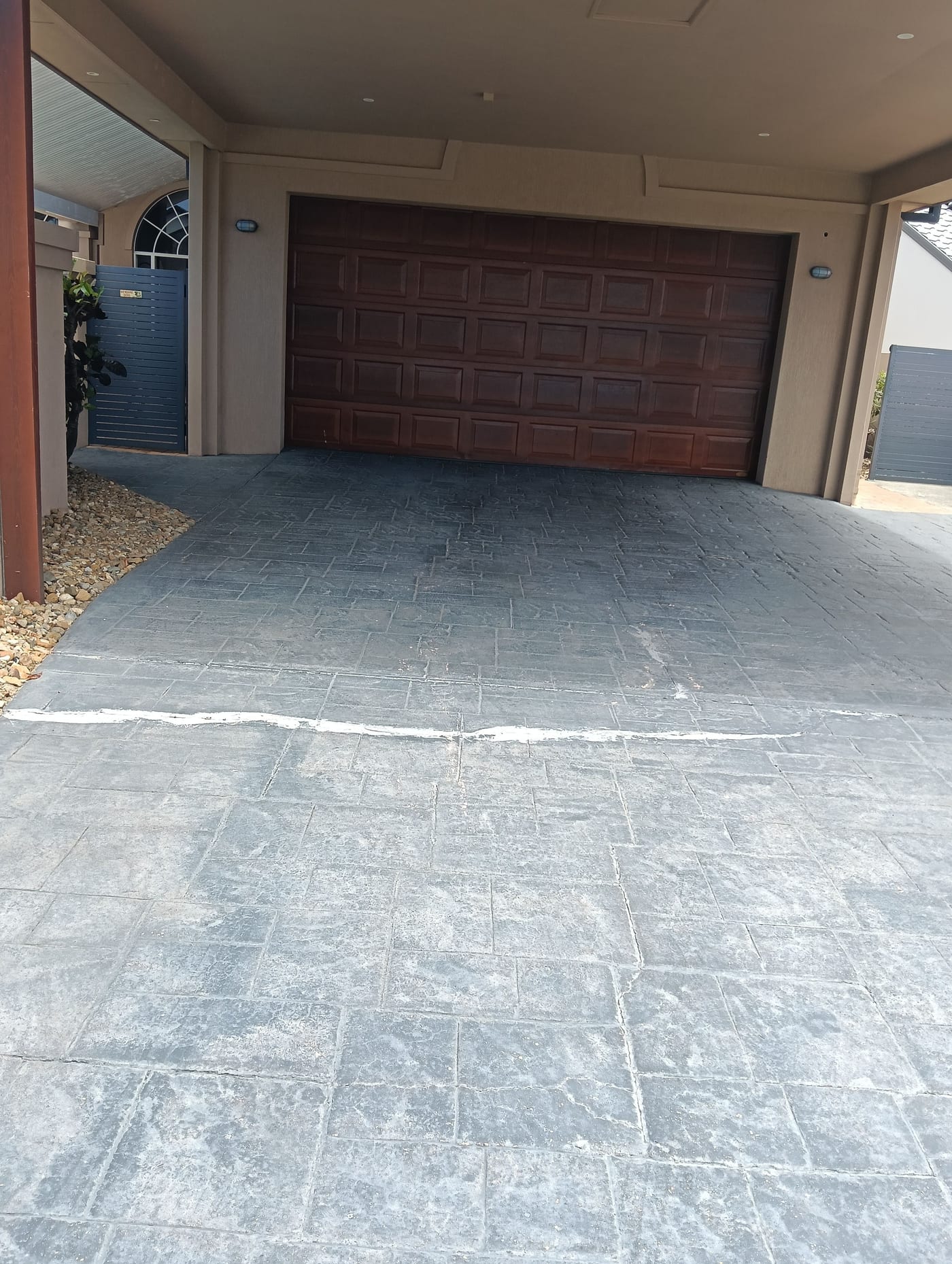 Gold Coast garage entry driveway cleaning result on a dark paved surface