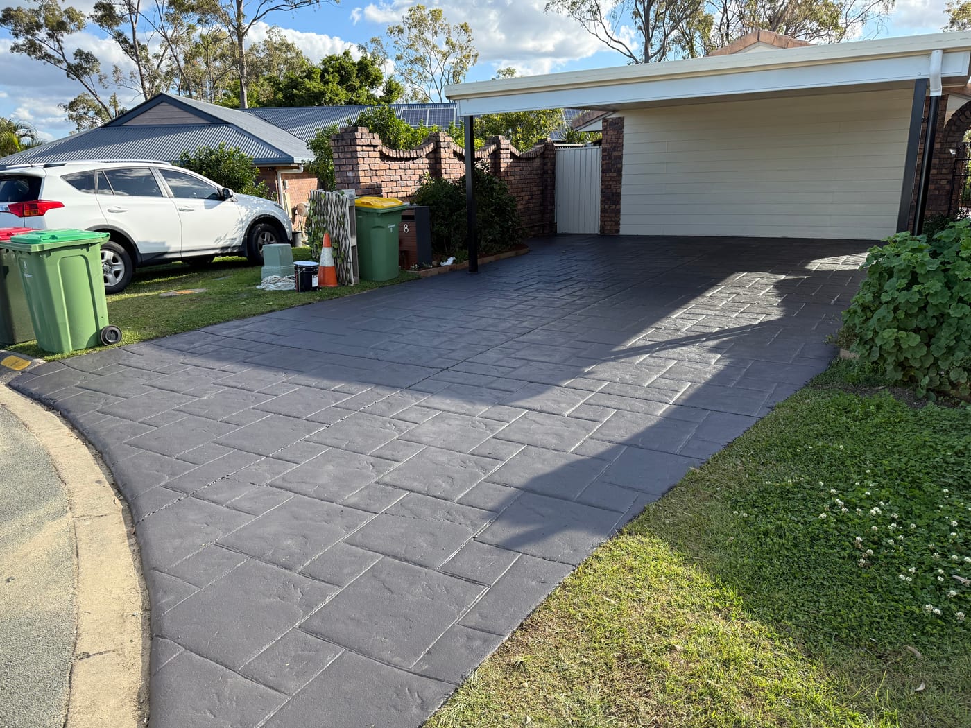 Gold Coast stamped concrete driveway cleaning result beside a garage