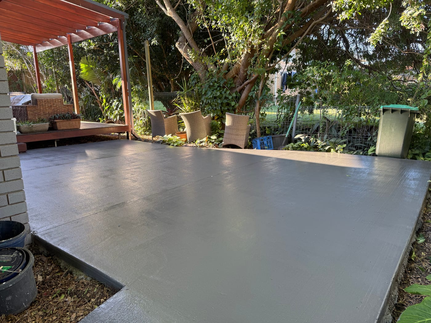 Gold Coast backyard patio cleaning result beside a garden and pergola